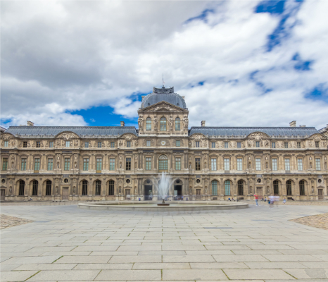 View of the Cour Carrée at the Louvre. Source: Adobe Stock Wide view of the Cour Carrée at the Louvre in Paris, showing the central fountain and the symmetrical palace façades under a cloudy sky