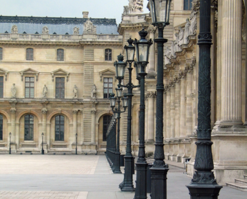 View of the Louvre’s eastern colonnade. Source: Fotolia / Adobe Stock View of the Louvre’s eastern colonnade in Paris, with Corinthian columns and a row of black lampposts leading toward the palace façade