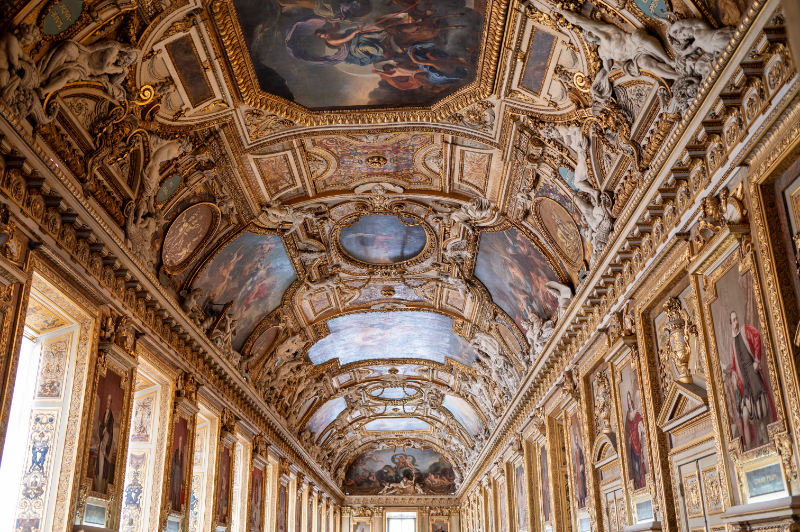 View of the Galerie d’Apollon at the Louvre in Paris, showing the richly decorated vaulted ceiling, gilded carvings, and painted panels
