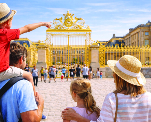 Family visiting the Palace of Versailles entrance with children