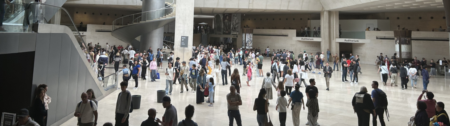 The Hall Napoléon Beneath the Louvre Pyramid View of the Hall Napoléon beneath the Louvre Pyramid, showing the large underground arrival space, escalators, glass structure overhead, and visitors moving through the central concourse.